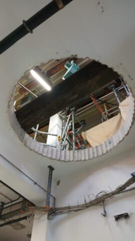 Große Kernbohrung durch Hallendecke von unten – Blick in Industriehalle