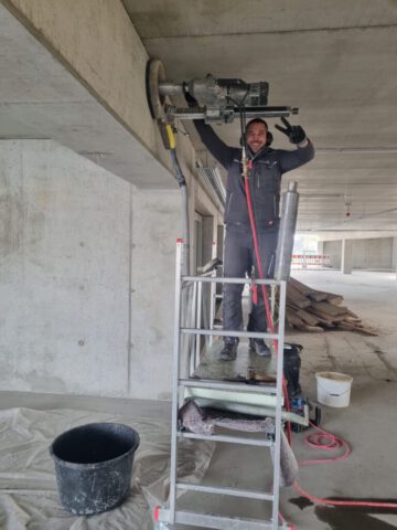 Mitarbeiter bei Kernbohrung an Betondecke im Rohbau