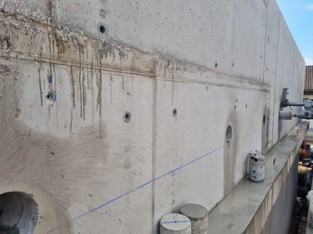 Kernbohrungen verschiedener Durchmesser in Betonwand mit Rohrleitungen Kernbohrungen verschiedener Durchmesser in Betonwand mit Rohrleitungen