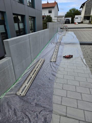 Vorbereitung Betonsägearbeiten an Betonmauer mit Führungsschiene und Abdeckfolie Vorbereitung Betonsägearbeiten an Betonmauer mit Führungsschiene und Abdeckfolie