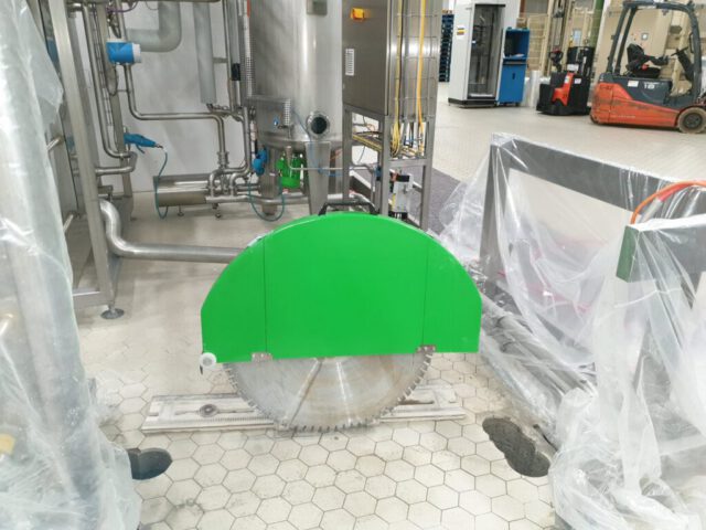 Bodensäge mit großem Sägeblatt in Industrieanlage auf Fliesenboden